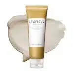 SKIN1004 Madagascar Centella Ampoule Foam tube over a creamy, light beige product swatch.