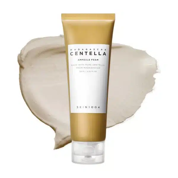 SKIN1004 Madagascar Centella Ampoule Foam tube over a creamy, light beige product swatch.