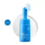 Seapuri Scalpy Bubble Tonic 100ml blue bottle with a built-in silicone brush head on a clear splash.