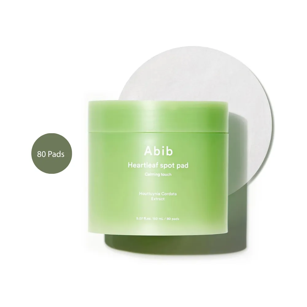 Abib Heartleaf Spot Pad Calming Touch (80 Pads) Abib Heartleaf Spot Pad Calming Touch 80 Pads light green jar with round cotton pad behind it.